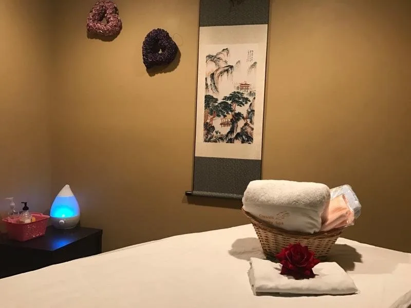 Massage table set with fresh towels and a red rose